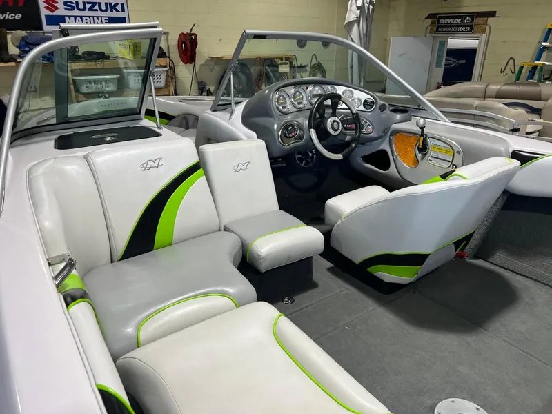 Slide: The Image of 2005 Nautique Super Air 210 boat interior with white and green seating, dashboard, and steering wheel. - 17