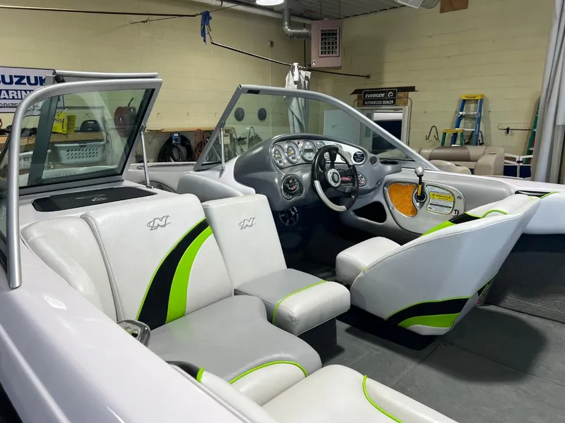 Slide: The Image of 2005 Nautique Super Air 210 boat interior with white and green seats, steering wheel, and dashboard. - 5