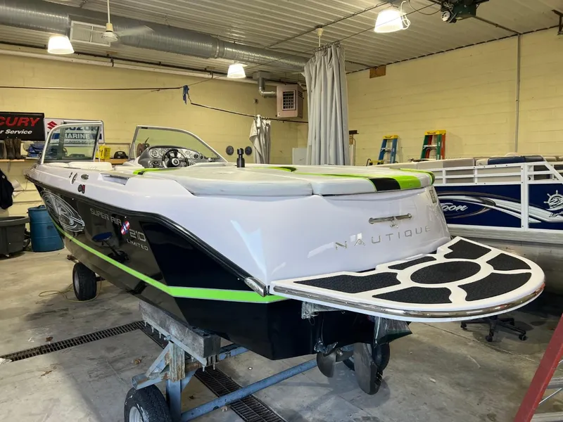 Slide: The Image of 2005 Nautique Super Air 210 boat in a garage, showcasing sleek design and vibrant colors. - 7