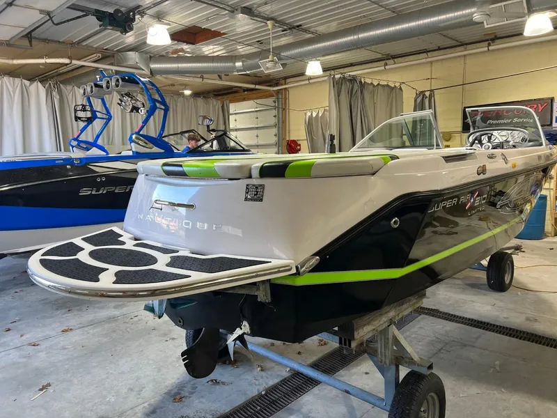 Slide: The Image of 2005 Nautique Super Air 210 boat in a garage, featuring sleek design and vibrant accents. - 8