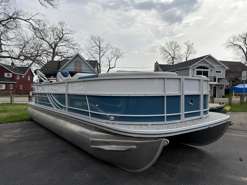 Slide: The Image of 2025 South Bay 224RS LE pontoon boat parked on a residential street. - 1