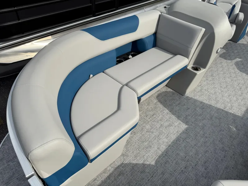 Slide: The Image of 2025 South Bay 224RS LE boat interior with blue and gray seating on carpeted floor. - 10