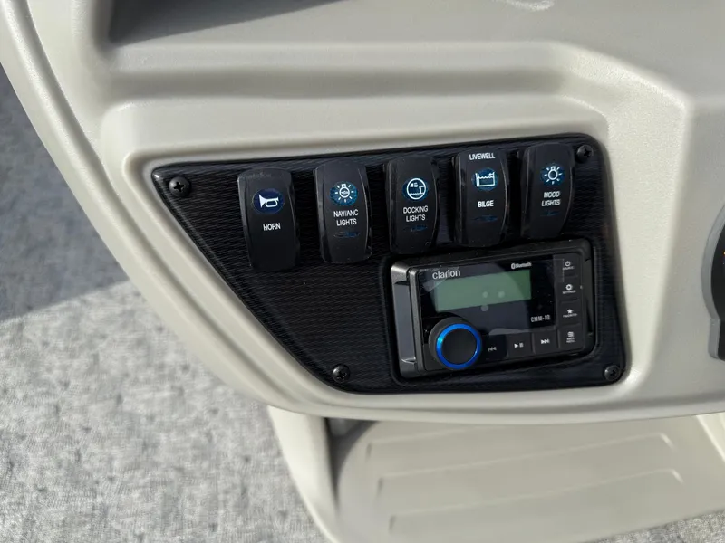 Slide: The Image of Control panel of 2025 South Bay 224RS LE boat with switches and Clarion audio system. - 18