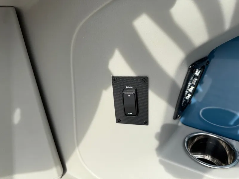 Slide: The Image of Switch panel and cup holder on 2025 South Bay 224RS LE boat interior. - 20