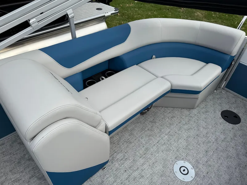 Slide: The Image of 2025 South Bay 224RS LE boat interior with blue and white seating on gray carpet. - 24