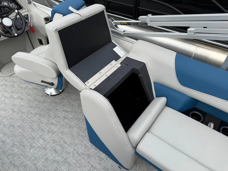 Slide: The Image of 2025 South Bay 224RS LE boat interior with blue and white seating and storage compartment. - 26
