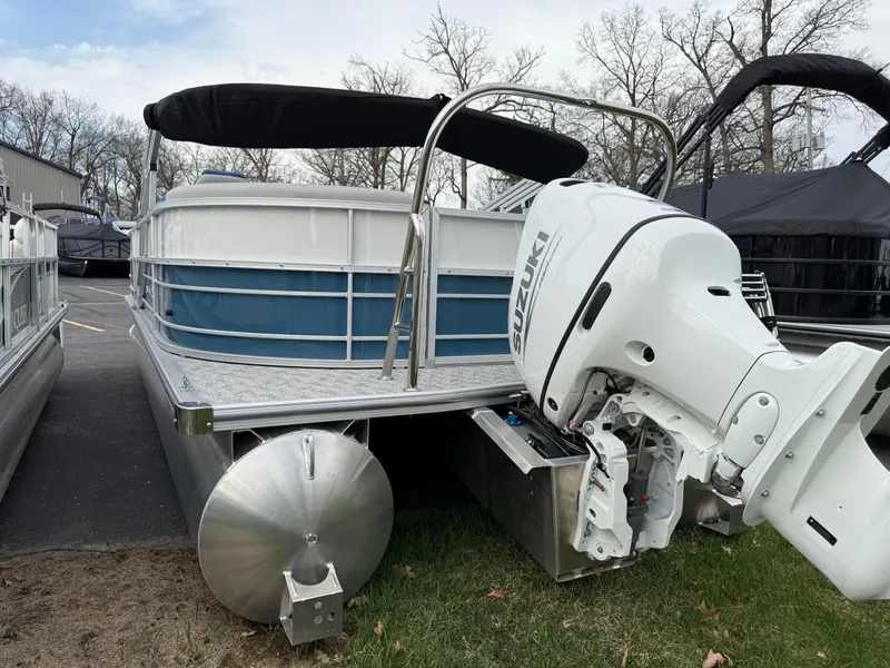 Slide: The Image of 2025 South Bay 224RS LE pontoon boat with Suzuki outboard motor, parked on grass. - 4