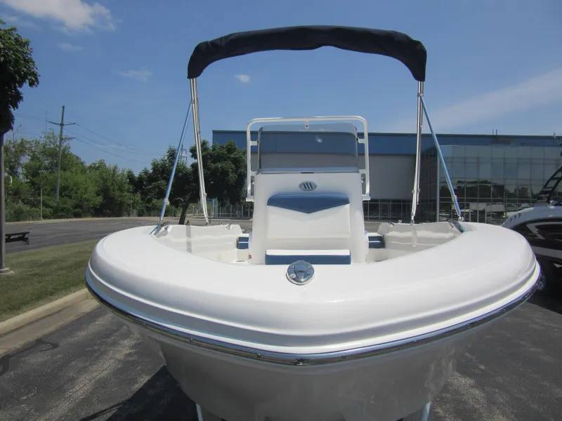 Slide: The Image of 2025 Robalo R160 Center Console boat with canopy, parked outdoors. - 4
