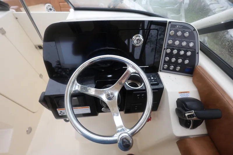 Slide: The Image of 2023 Scout 255 Dorado boat dashboard with steering wheel and control panel. - 39