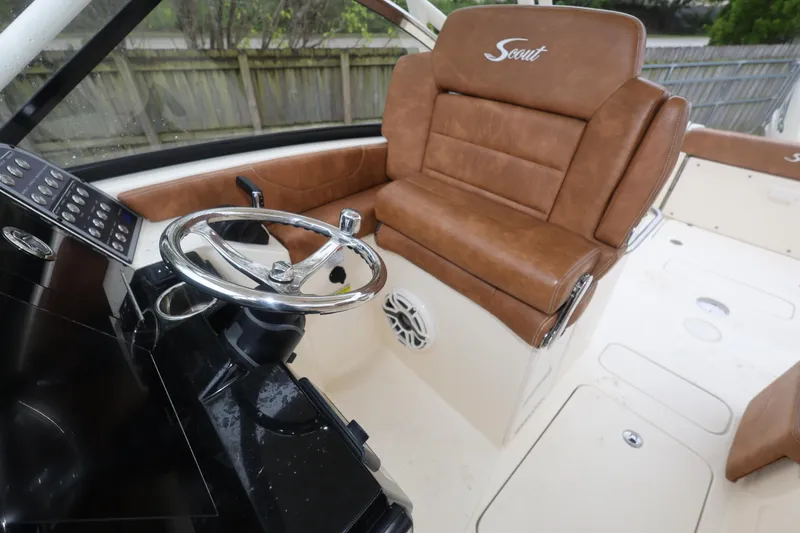 Slide: The Image of 2023 Scout 255 Dorado boat interior with brown leather seating and steering wheel. - 42