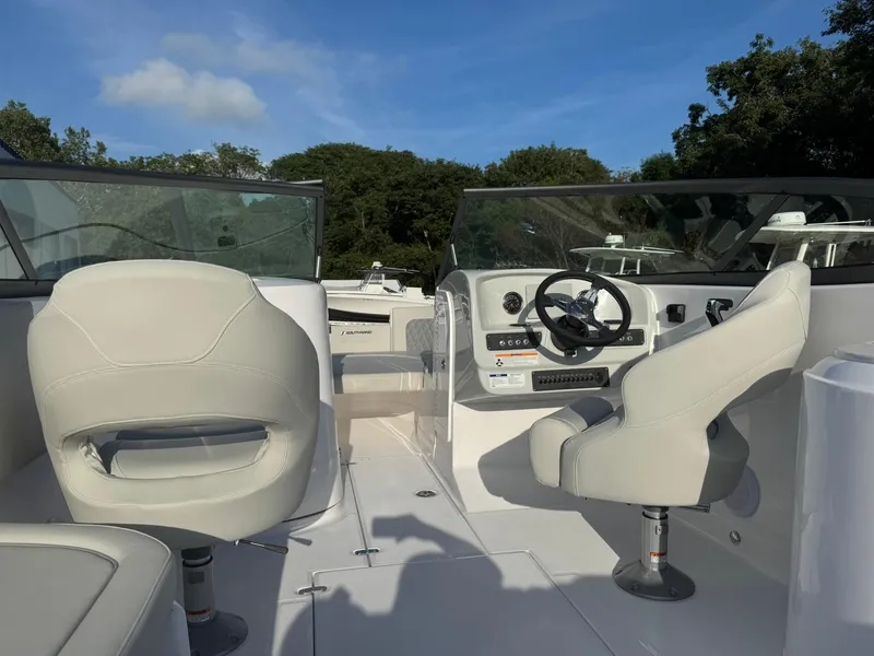 Slide: The Image of 2025 SouthWind 2600 boat interior with steering wheel and seating under clear blue sky. - 3