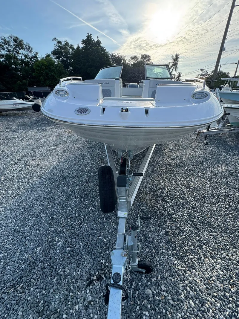 Slide: The Image of 2025 SouthWind 2600 boat on trailer, parked on gravel lot under a sunny sky. - 7