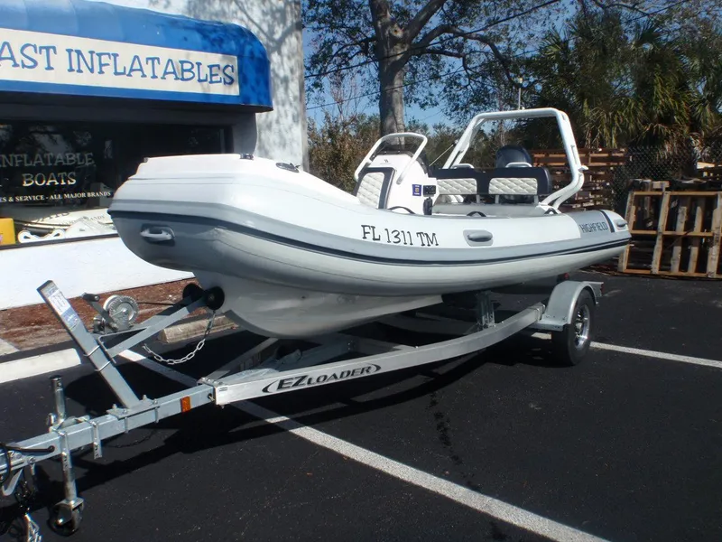 Slide: The Image of 2023 Highfield Sport 420 inflatable boat on trailer, parked outside dealership. - 2