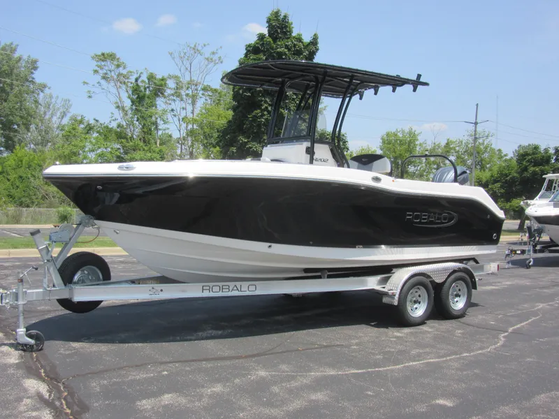 The Image of 2025 Robalo R202 Explorer boat on trailer, black hull, parked outdoors. - 0