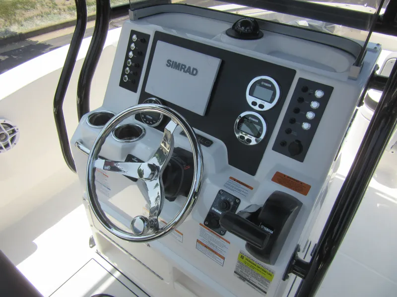 Slide: The Image of 2025 Robalo R202 Explorer boat dashboard with steering wheel and control panel. - 13