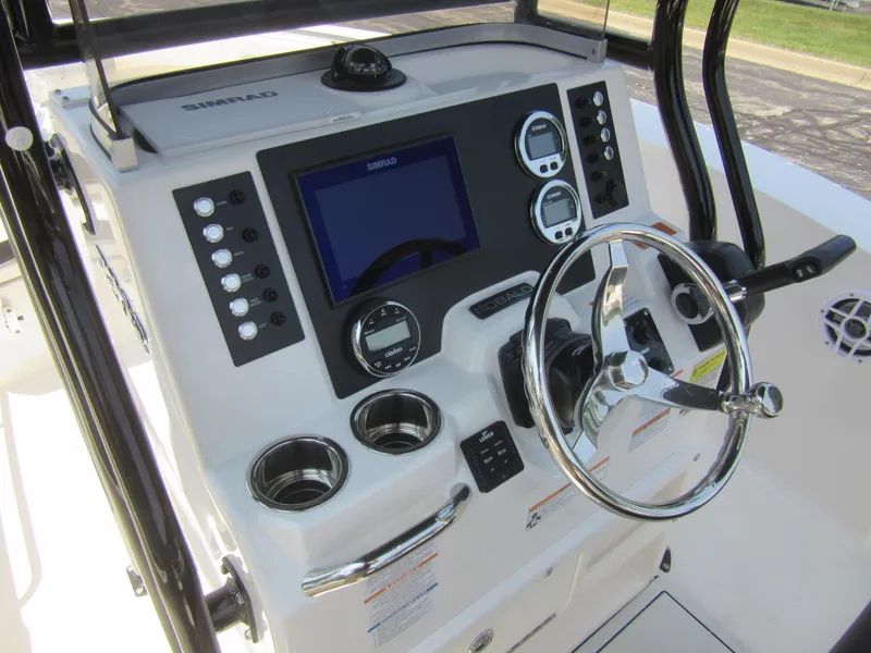 Slide: The Image of 2025 Robalo R202 Explorer boat dashboard with steering wheel and control panel. - 15