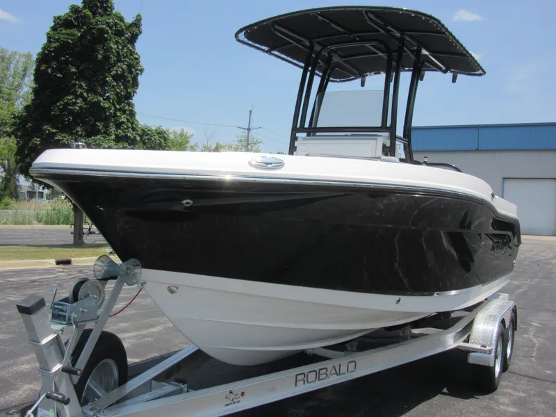 Slide: The Image of 2025 Robalo R202 Explorer boat on trailer, black hull, T-top, outdoor setting. - 2