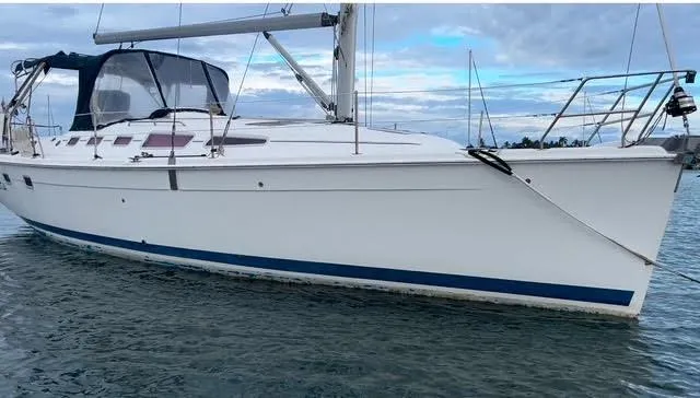 Slide: The Image of 2006 Hunter 38 sailboat on calm water under a cloudy sky. - 1