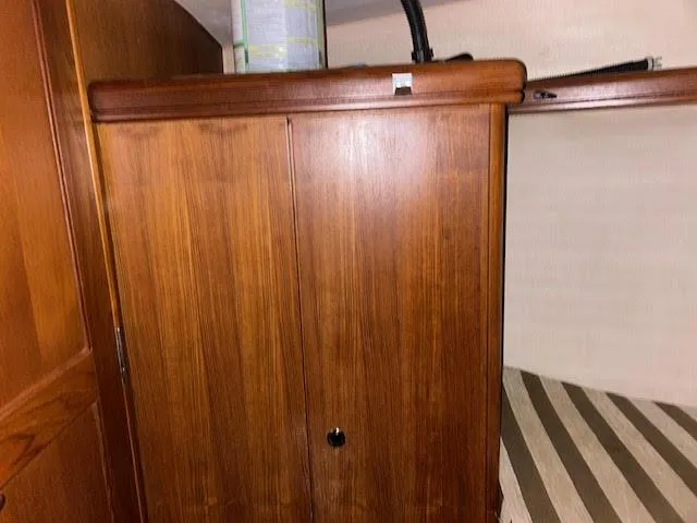 Slide: The Image of Interior cabin of 2006 Hunter 38 sailboat with wooden cabinetry and striped bedding. - 14