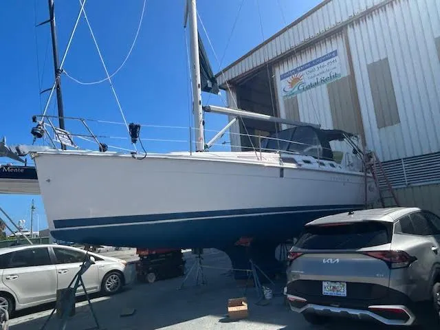 Slide: The Image of 2006 Hunter 38 sailboat on calm water under a cloudy sky. - 2