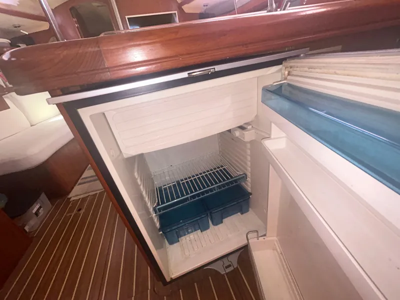 Slide: The Image of Open refrigerator in 2006 Hunter 38 yacht interior, wooden cabinetry, and stainless steel handle. - 34