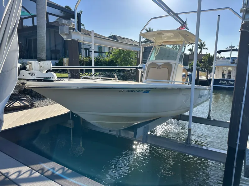 Slide: The Image of 2017 Scout 251 XS boat docked on a lift in a sunny marina. - 0