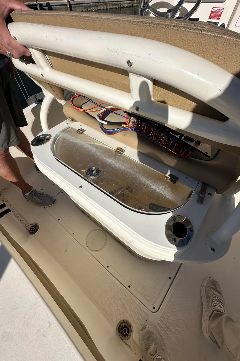 Slide: The Image of 2017 Scout 251 XS boat interior showing open storage compartment with wiring. - 8