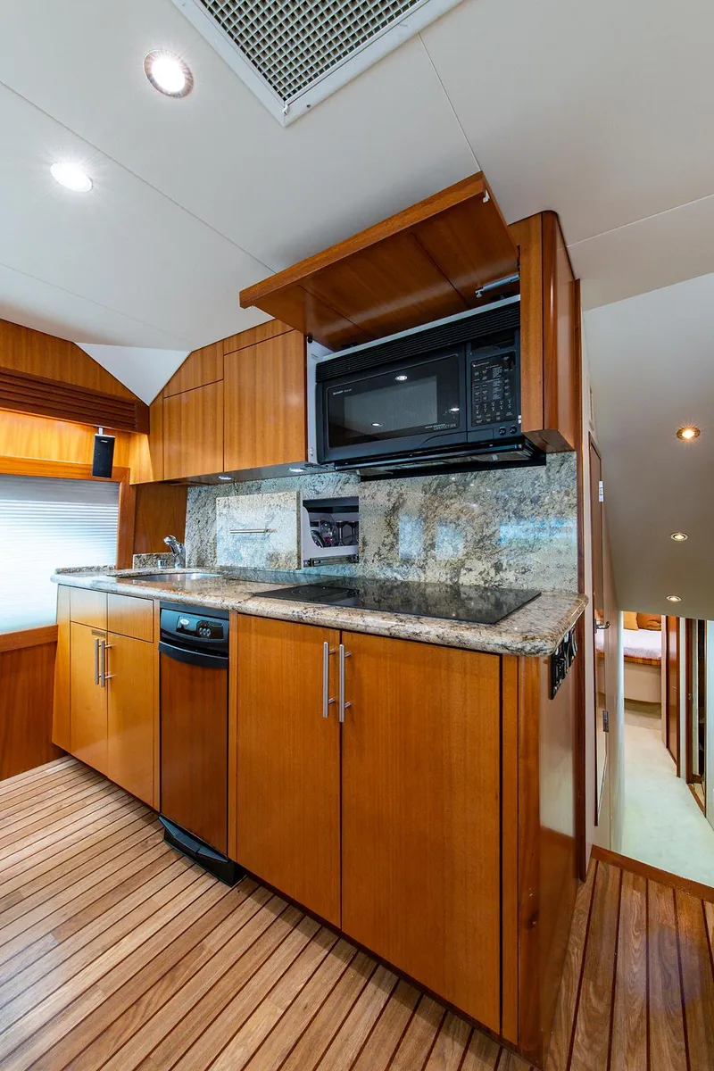 Slide: The Image of 2006 Hatteras 64 Convertible yacht kitchen with wood cabinetry and modern appliances. - 13