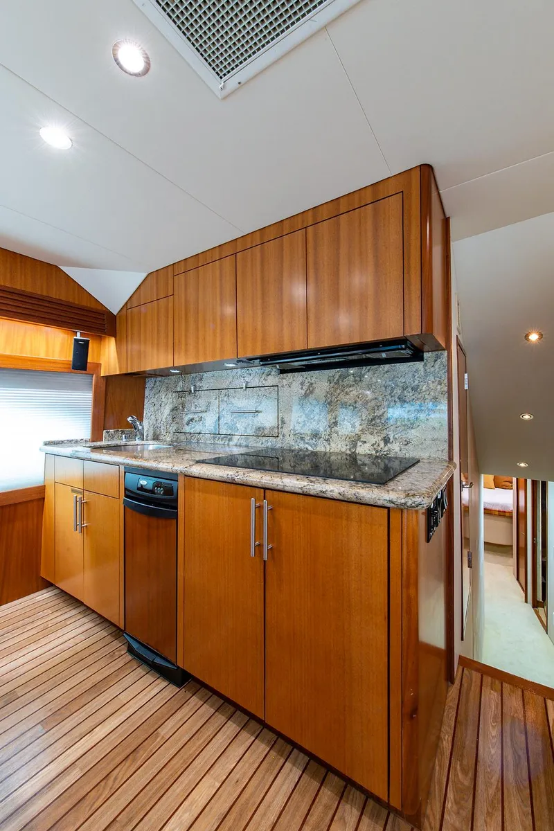 Slide: The Image of Interior of 2006 Hatteras 64 Convertible yacht with wooden cabinetry and modern appliances. - 17