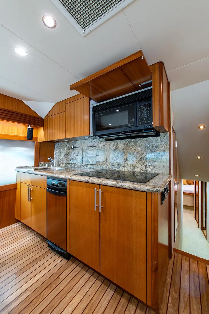 Slide: The Image of 2006 Hatteras 64 Convertible yacht kitchen with wood cabinetry and granite countertops. - 18