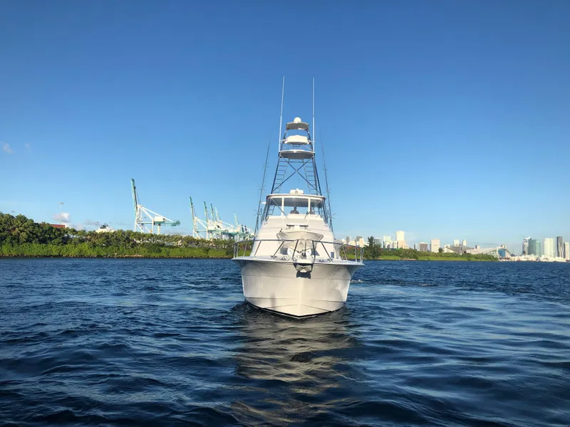 Slide: The Image of 2006 Hatteras 64 Convertible yacht on calm water, clear blue sky background. - 2