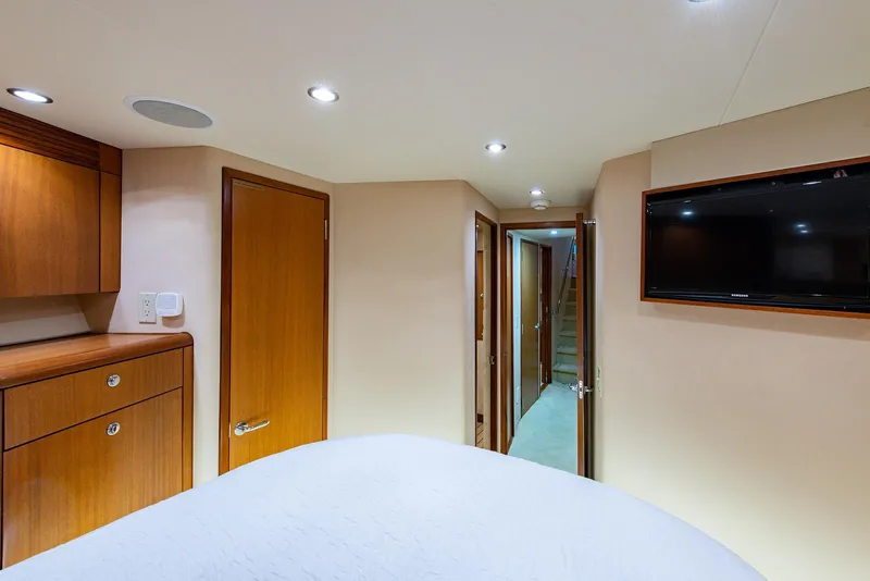 Slide: The Image of Interior of 2006 Hatteras 64 Convertible yacht, featuring wood cabinetry and a wall-mounted TV. - 23