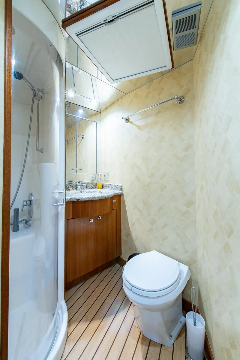 Slide: The Image of Bathroom interior of 2006 Hatteras 64 Convertible yacht, featuring shower and wooden flooring. - 24