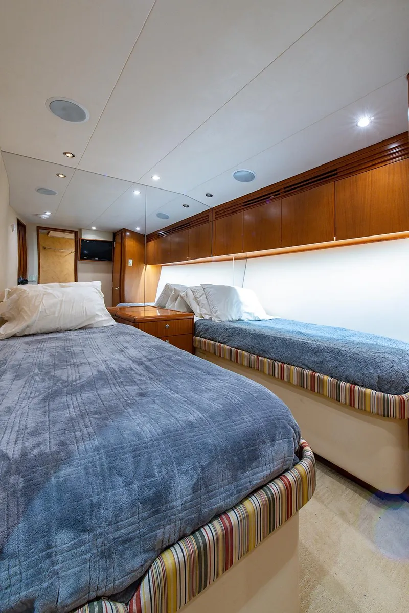 Slide: The Image of Interior of 2006 Hatteras 64 Convertible yacht with twin beds and wooden cabinetry. - 28