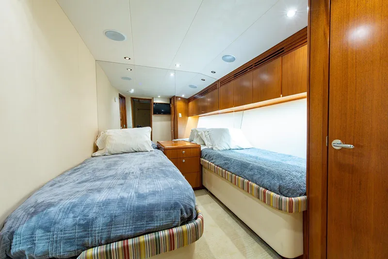 Slide: The Image of Interior of 2006 Hatteras 64 Convertible yacht with twin beds and wooden cabinetry. - 30