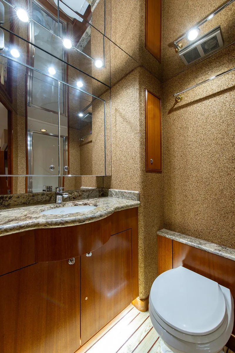 Slide: The Image of Luxurious bathroom in 2006 Hatteras 64 Convertible yacht with granite countertop and wooden cabinetry. - 33
