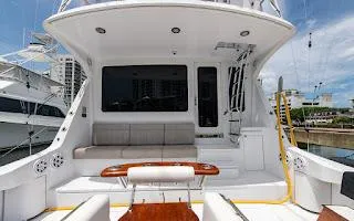 Slide: The Image of 2006 Hatteras 64 Convertible yacht deck with seating and table, docked in marina. - 4