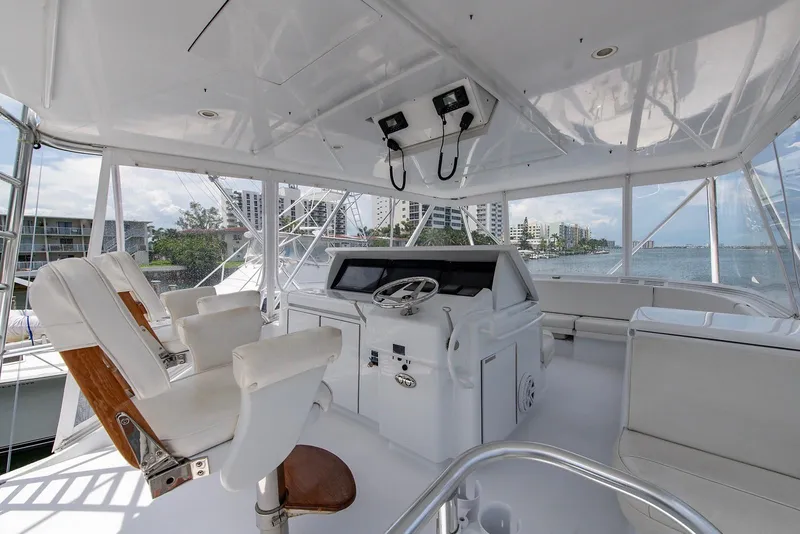Slide: The Image of 2006 Hatteras 64 Convertible yacht helm with white seating and panoramic water views. - 45