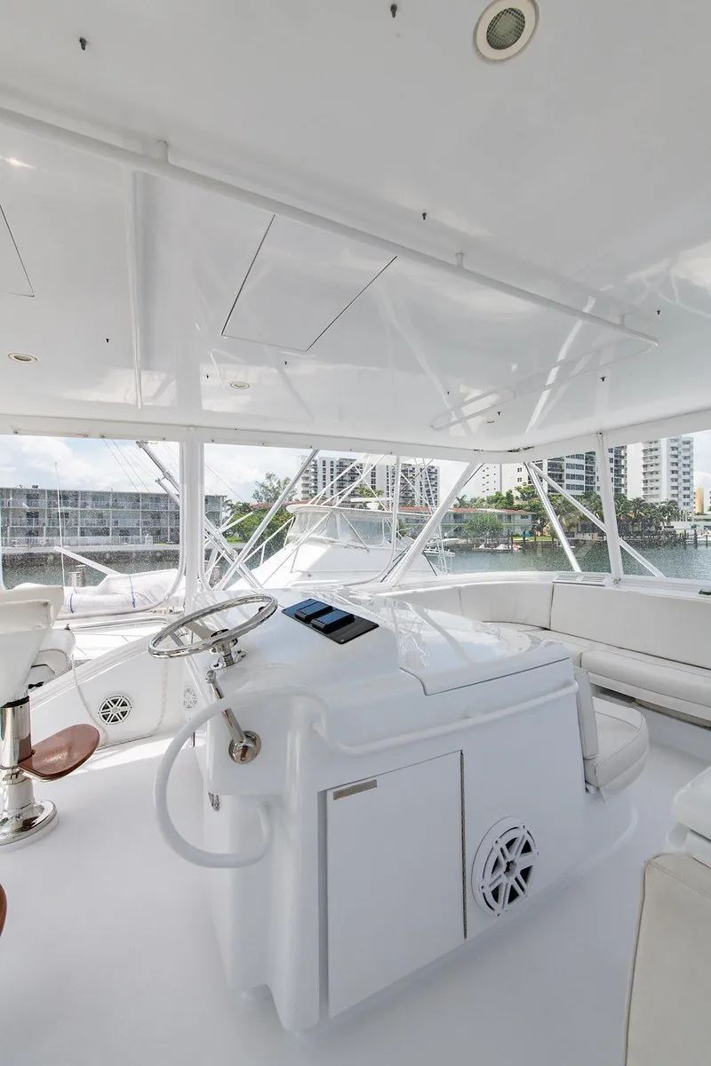 Slide: The Image of Interior of 2006 Hatteras 64 Convertible yacht, featuring sleek white design and modern controls. - 46