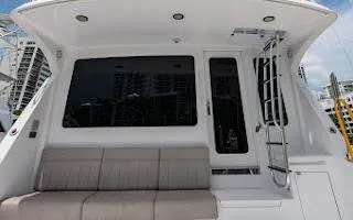 Slide: The Image of 2006 Hatteras 64 Convertible yacht with seating and ladder, docked in a marina. - 5