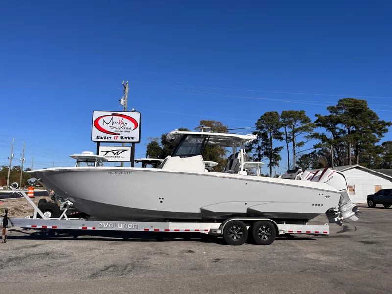 The Image of 2023 Fountain 32 NX boat on trailer at marina, clear sky background. - 1