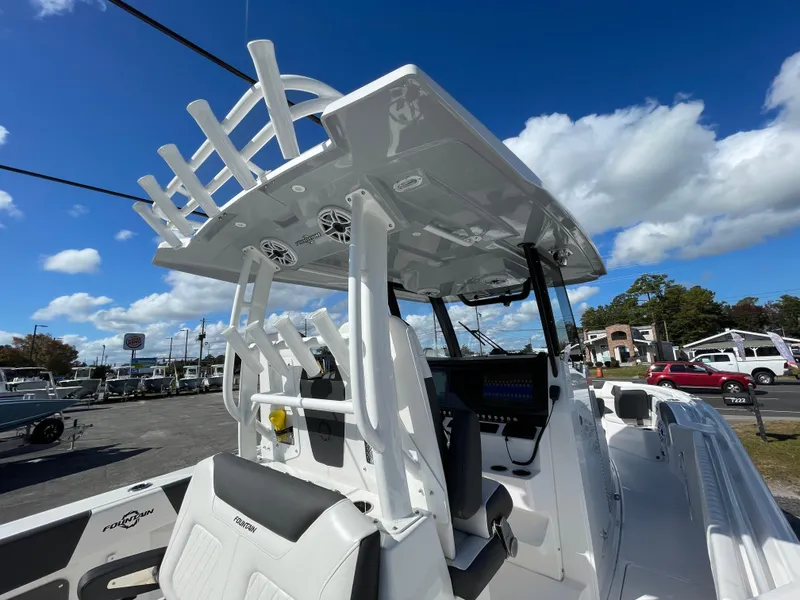 Slide: The Image of 2023 Fountain 32 NX boat with T-top and seating, under a clear blue sky. - 11