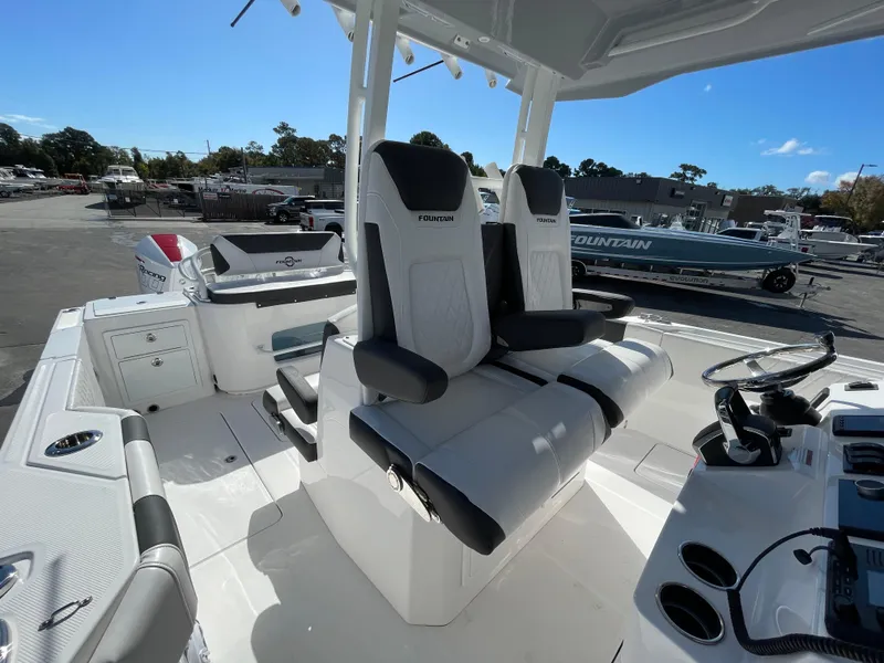 Slide: The Image of 2023 Fountain 32 NX boat interior with dual captain's chairs and control panel. - 13