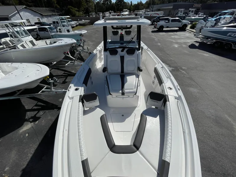 Slide: The Image of 2023 Fountain 32 NX boat with sleek design, parked in a marina. - 17