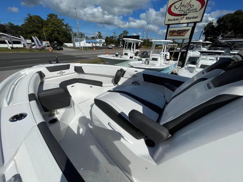 Slide: The Image of 2023 Fountain 32 NX boat with sleek seating, displayed at a marine dealership. - 18
