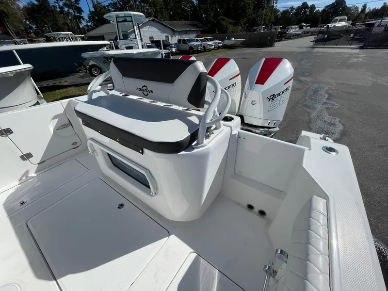 Slide: The Image of 2023 Fountain 32 NX boat with dual outboard motors, white seating, and spacious deck. - 7