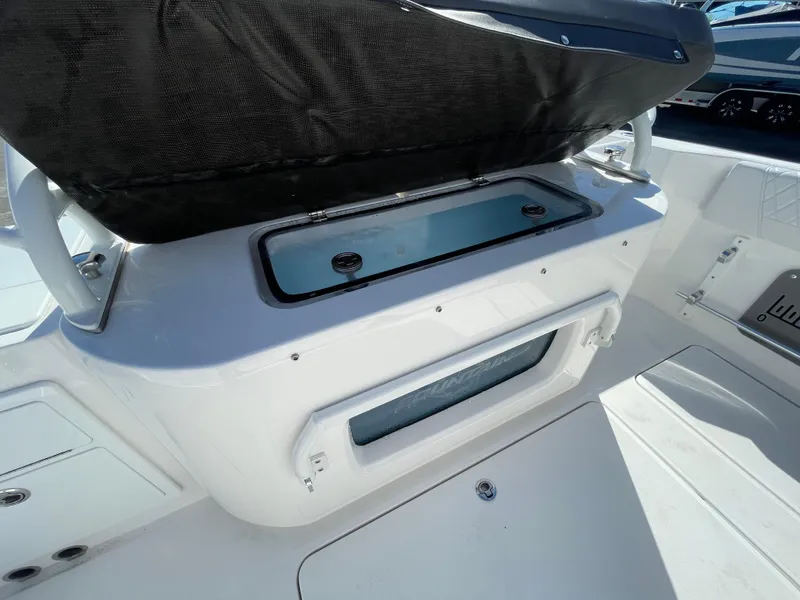 Slide: The Image of 2023 Fountain 32 NX boat interior with storage compartment and seating area. - 8