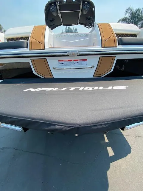Slide: The Image of 2021 Nautique Super Air Nautique GS24 boat rear view with cover. - 12