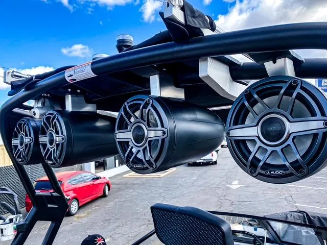 Slide: The Image of 2021 Nautique Super Air Nautique GS24 boat speakers, mounted on a black tower, under blue sky. - 27