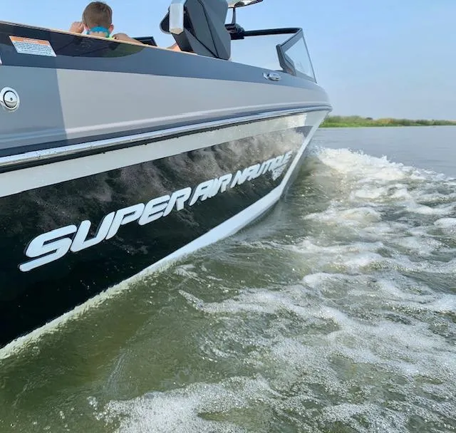 Slide: The Image of 2021 Nautique Super Air Nautique GS24 cruising on water, side view. - 29